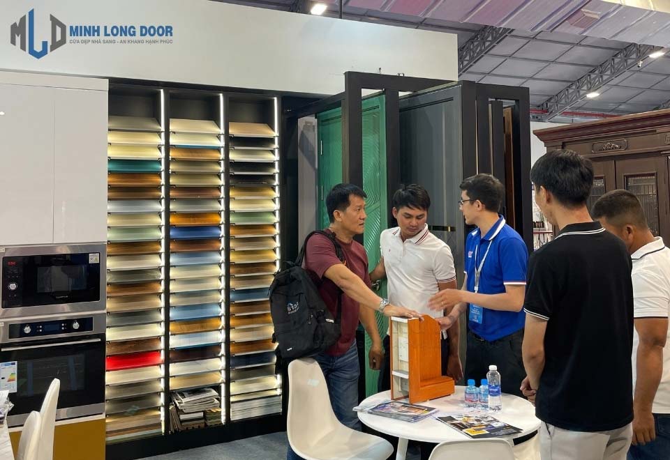 Nhân viên Minh Long Door đang tư vấn cửa composite cho khách hàng tại triển lãm Vietbuild 2024